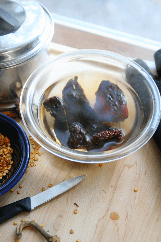 Dried peppers sitting in boiling water.