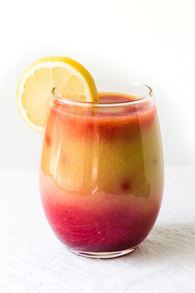 Sunrise detox smoothie in a glass with a lemon slice.