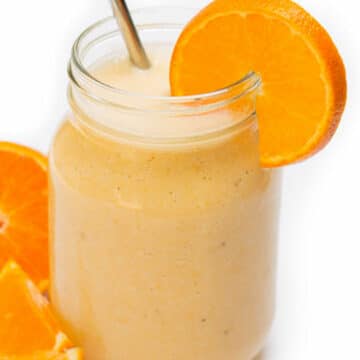 Orange Banana Smoothie with a metal straw.