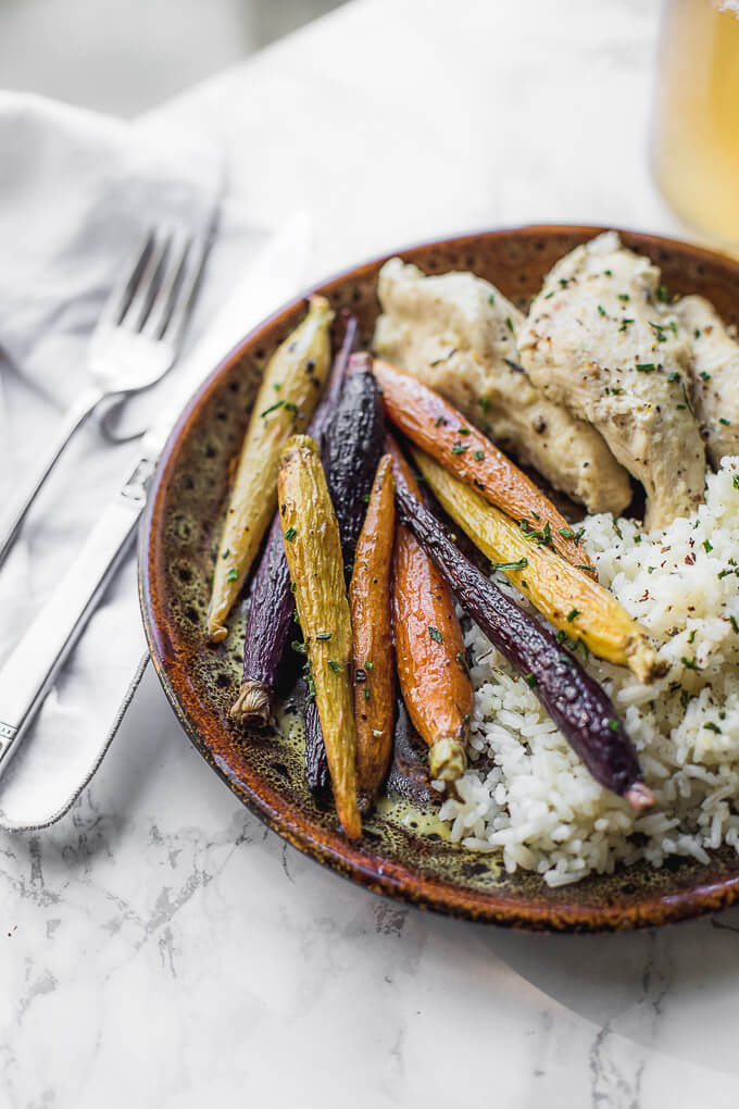 Roasted carrots with chicken and rice on a plate.