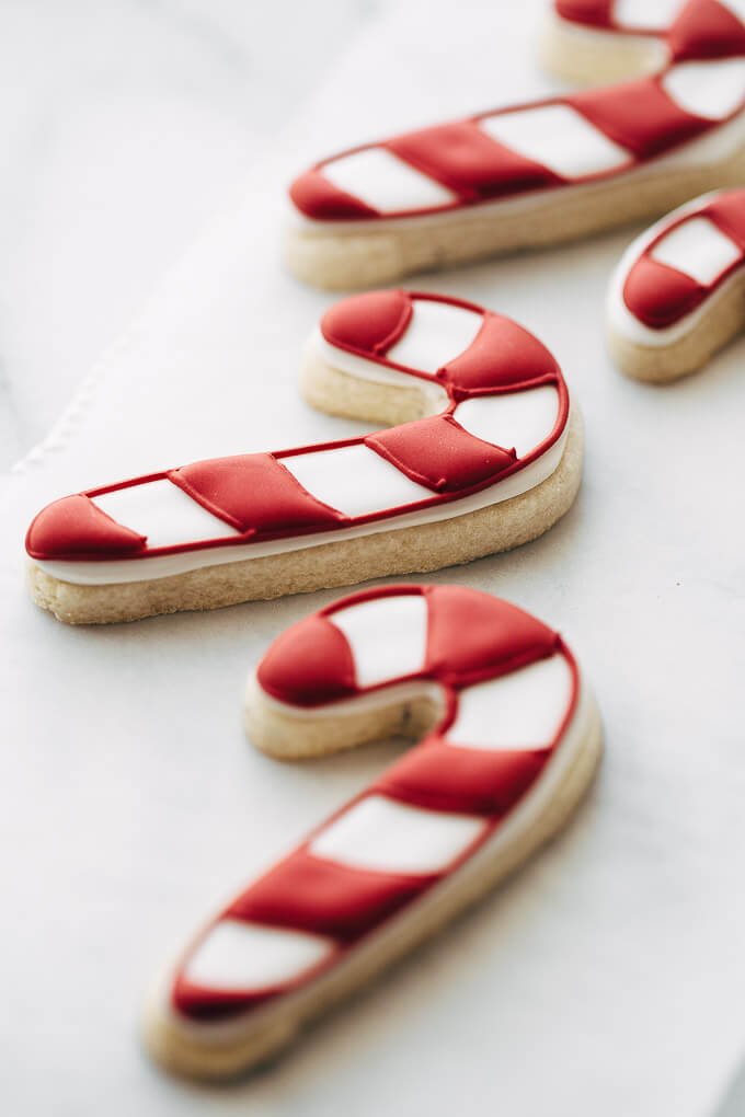 Candy cane sugar cookies on a piece of parchment.
