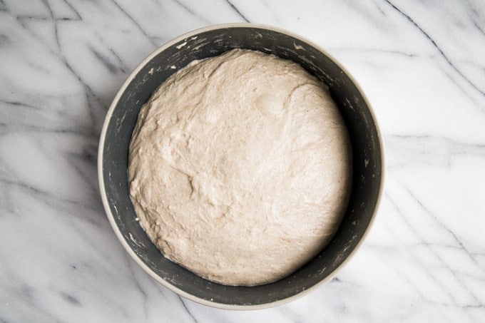 The dough in a bowl showing that the bulk ferment of the sourdough is complete.