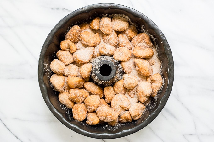 Biscuit pieces coated in cinnamon sugar in a bundt pan.l