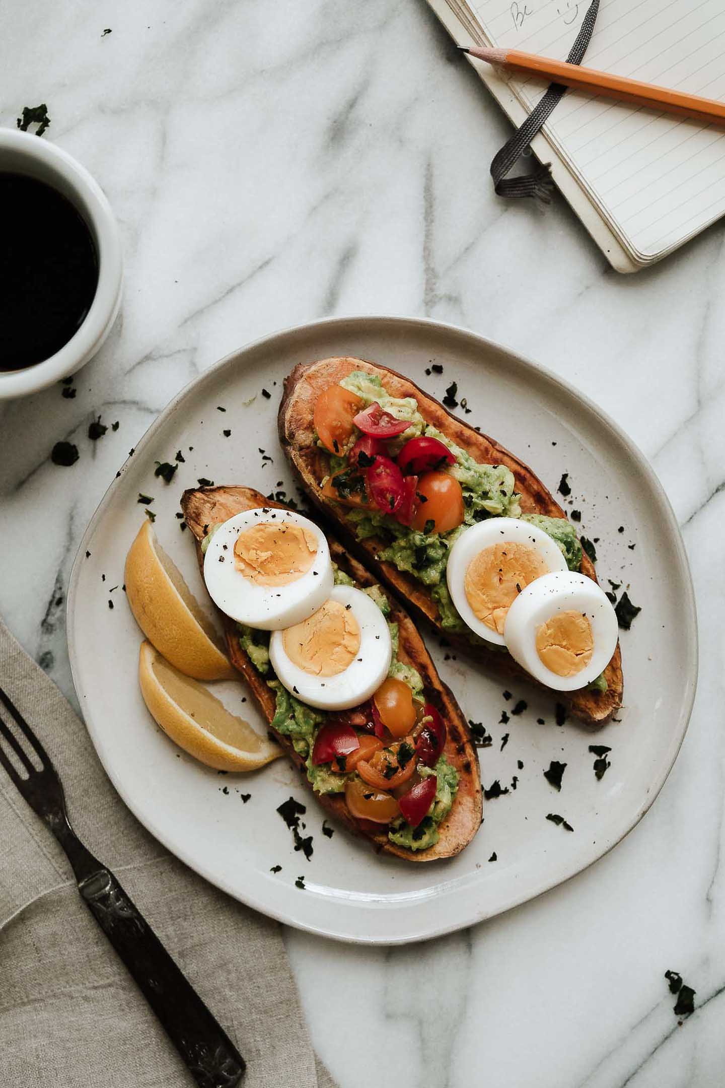 Sweet potato toast topped with eggs, tomatoes and avocado.