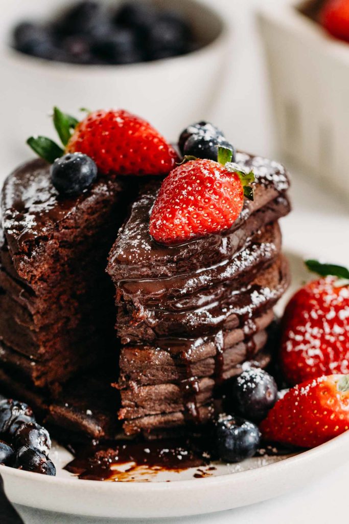Gluten-Free Chocolate Pancakes are simple to make with wholesome ingredients. An allergy friendly pancake recipe with delicious hot chocolate sauce and berries. #glutefree #glutenfreepancakes #valentinesdayrecipe #chocolatepancakes #pancakes
