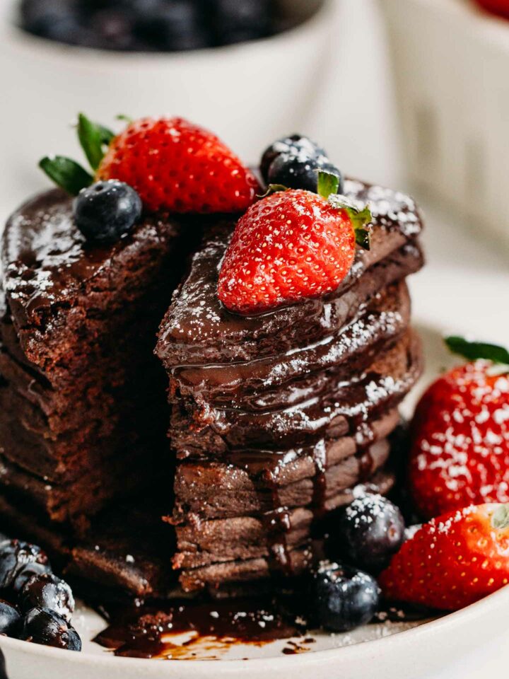 Gluten-Free Chocolate Pancakes are simple to make with wholesome ingredients. An allergy friendly pancake recipe with delicious hot chocolate sauce and berries. #glutefree #glutenfreepancakes #valentinesdayrecipe #chocolatepancakes #pancakes