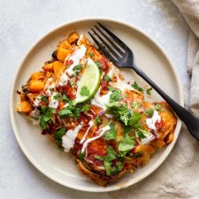 sweet potato enchiladas on a plate with a fork and napkin