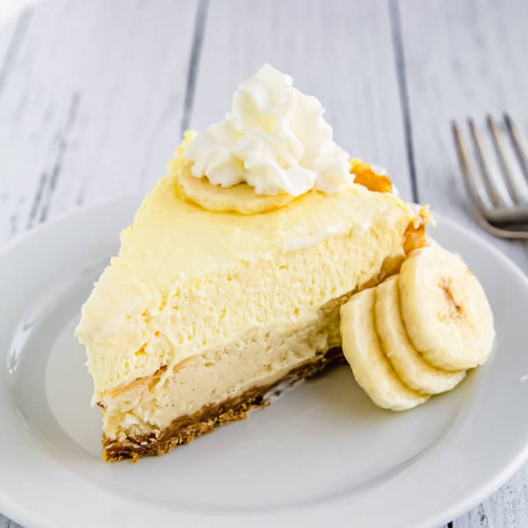 Banana Cream Pie Cheesecake Recipe Amy In The Kitchen   Banana Cheesecake Slice On A Plate With Bananas 768x768 