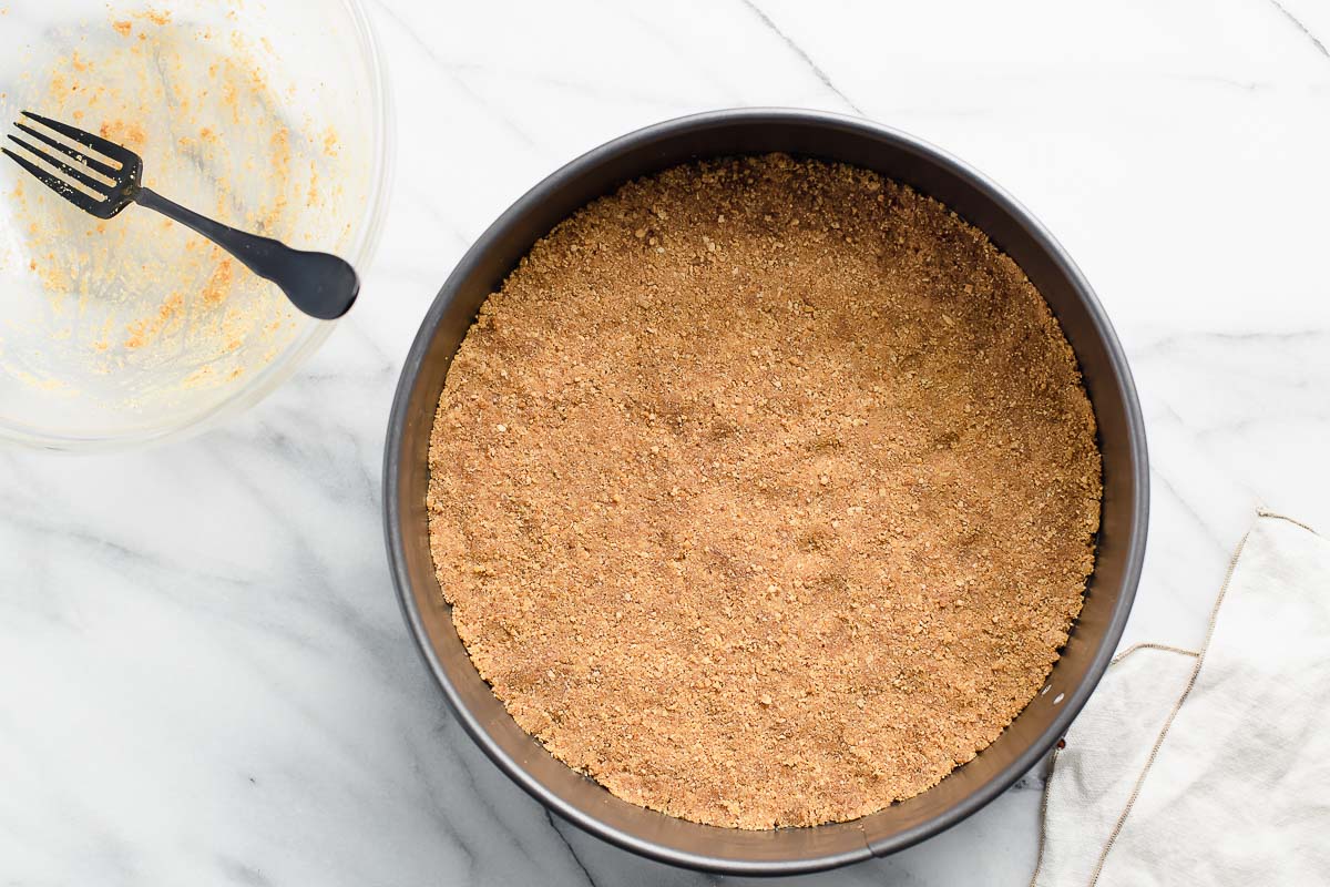 A graham cracker crust pressed into a spring-form pan.