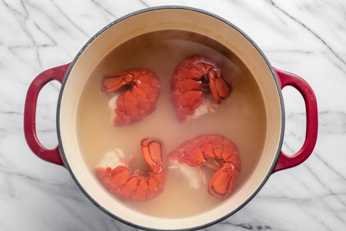 Four lobster tails in boiling water.