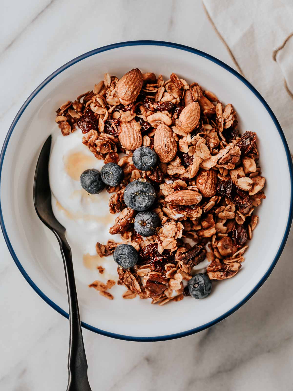 Granola and fresh blueberries in a bowl with yogurt.