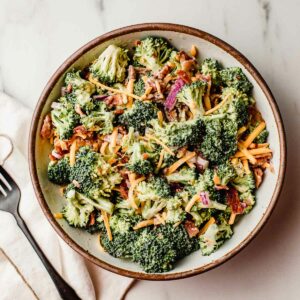 Broccoli salad in a bowl with a fork.