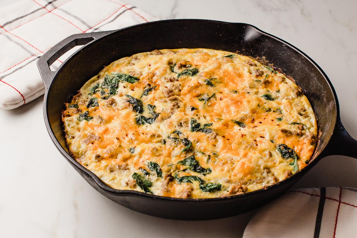 A baked turkey sausage and spinach frittata on a table.