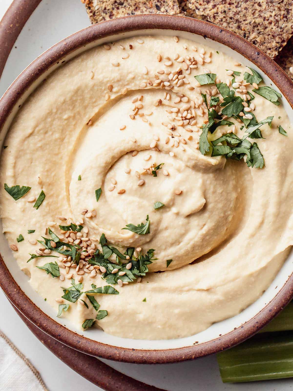 Oil free hummus in a bowl with sesame seeds on top.