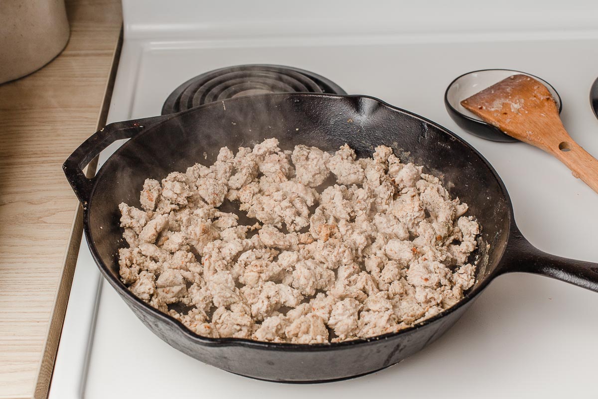 Turkey sausage browning in a skillet.