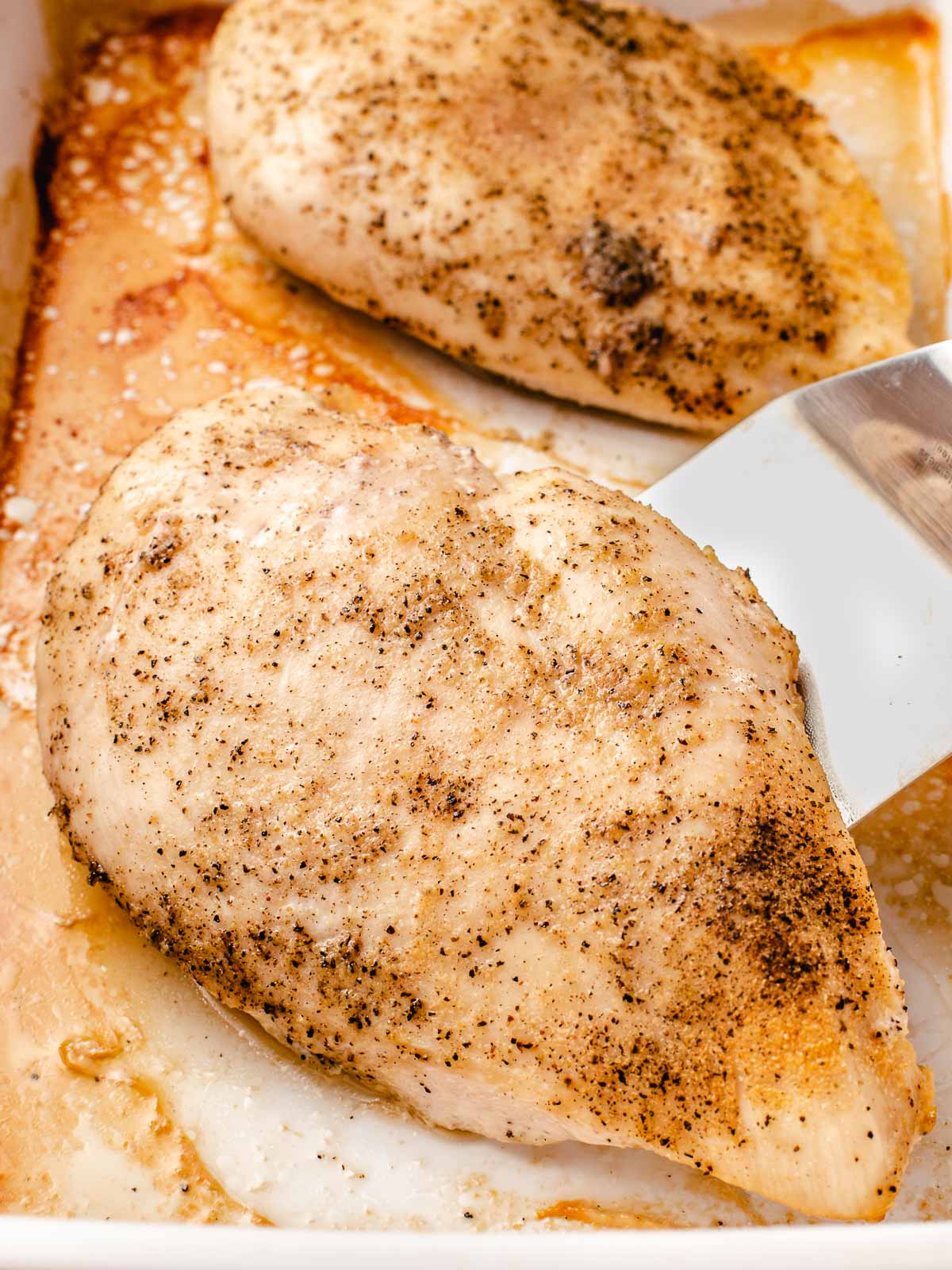 Baked chicken breast in a baking dish.
