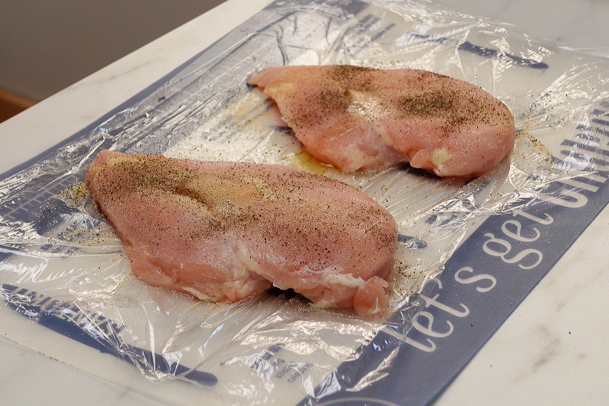 Two chicken breasts with seasoning.