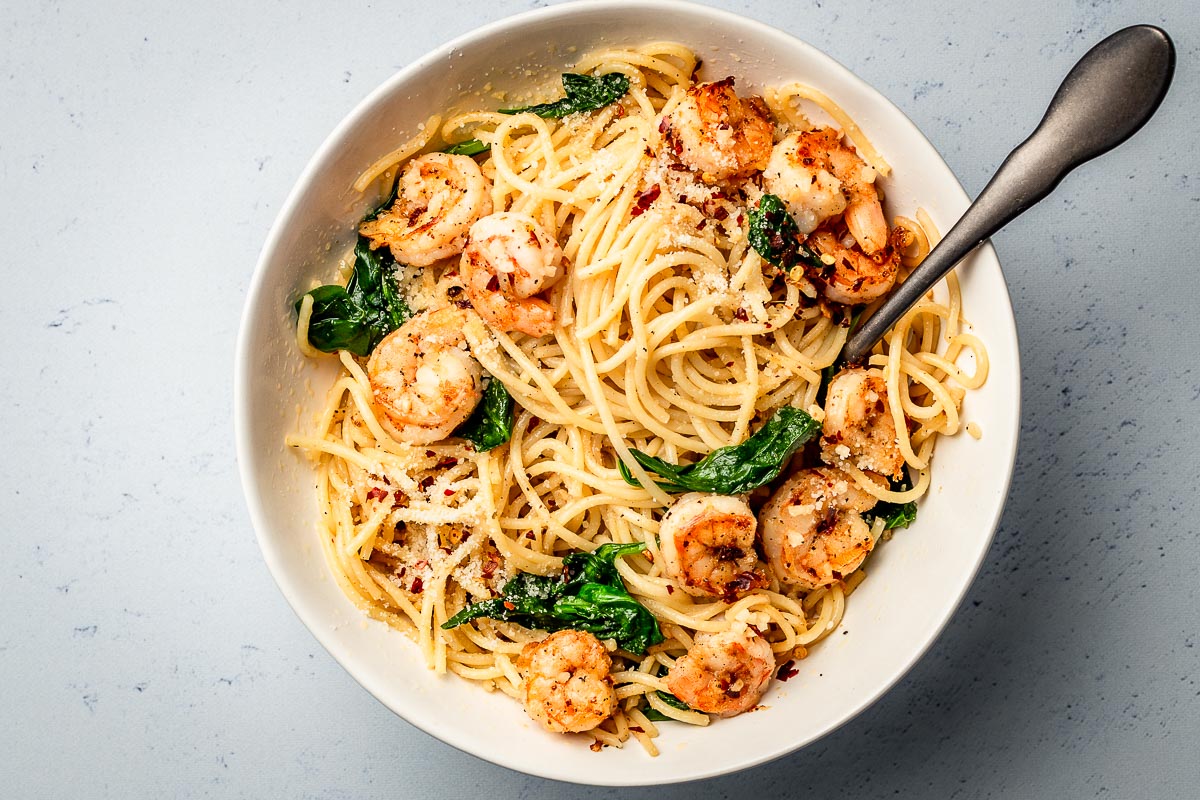 Pasta with garlic butter shrimp  bowl with spoon.