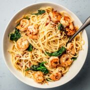 A bowl of pasta with garlic butter shrimp.